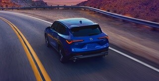 Vista trasera de la Acura ADX A-Spec 2025 con Paquete Avanzado en Adriatic Sea Blue Metallic en la carretera Vista trasera de la Acura ADX A-Spec 2025 con Paquete Avanzado en Adriatic Sea Blue Metallic en la carretera