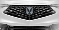 Se muestra la Acura ADX 2026 en Platinum White Pearl con el emblema frontal iluminado accesorio.