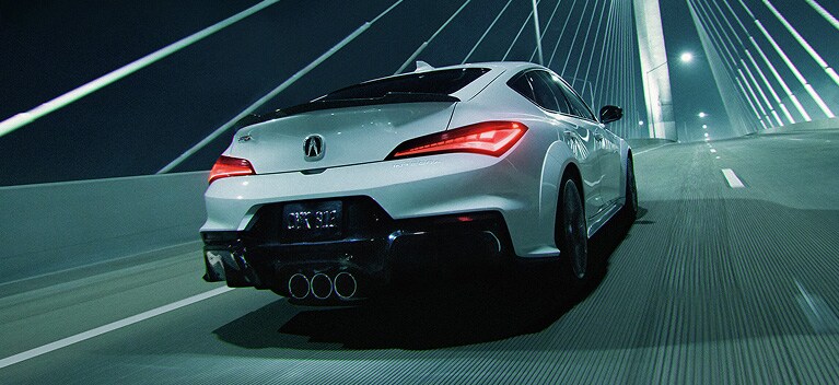 Se muestra el Acura Integra Type S 2026 en Platinum White Pearl sobre un puente de noche Se muestra el Acura Integra Type S 2026 en Platinum White Pearl sobre un puente de noche