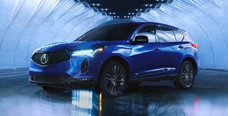 Perfil de 3/4 de la ACURA RDX 2022 con detalles llamativos en negro en un depósito Perfil de 3/4 de la ACURA RDX 2022 con detalles llamativos en negro en un depósito