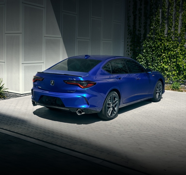 Vista trasera de 3/4 del Acura TLX 2025 con Paquete A-Spec en Apex Blue Pearl.