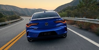 Vista trasera del Acura TLX 2025 con Paquete A-Spec en Apex Blue Pearl en la carretera. Vista trasera del Acura TLX 2025 con Paquete A-Spec en Apex Blue Pearl en la carretera.