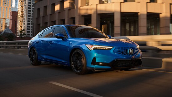 Acura Integra 2026 con Paquete A-Spec y Paquete Tecnológico en Double Apex Blue Pearl manejando por una calle urbana (compacto deportivo prémium).