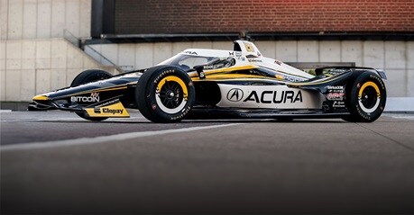 Perfil de un Acura 2026 estacionado en el pavimento de una pista de carreras profesional al aire libre.