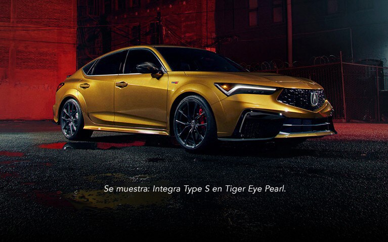 Vista frontal de 3/4 del Acura Integra Type S en Tiger Eye Pearl de noche.